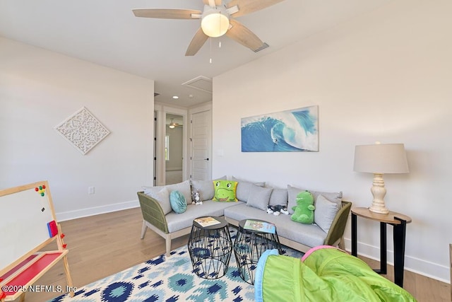 living area featuring attic access, wood finished floors, and baseboards