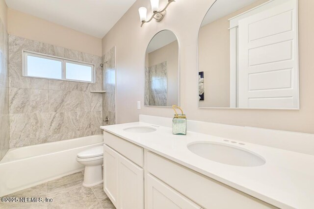 full bath with bathing tub / shower combination, toilet, double vanity, and a sink