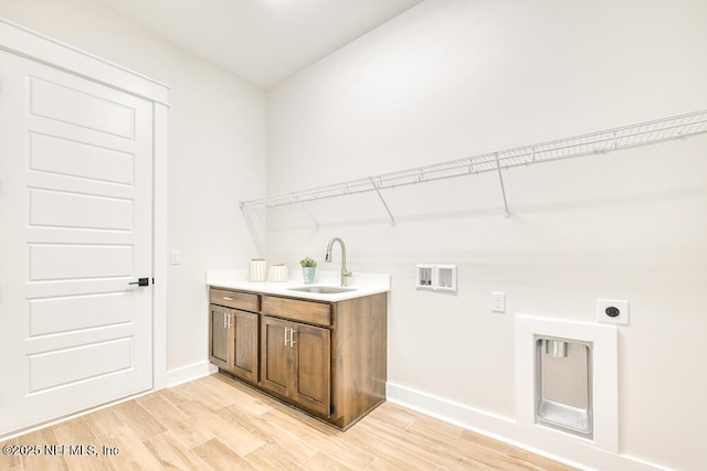 laundry area with light wood finished floors, washer hookup, baseboards, a sink, and electric dryer hookup