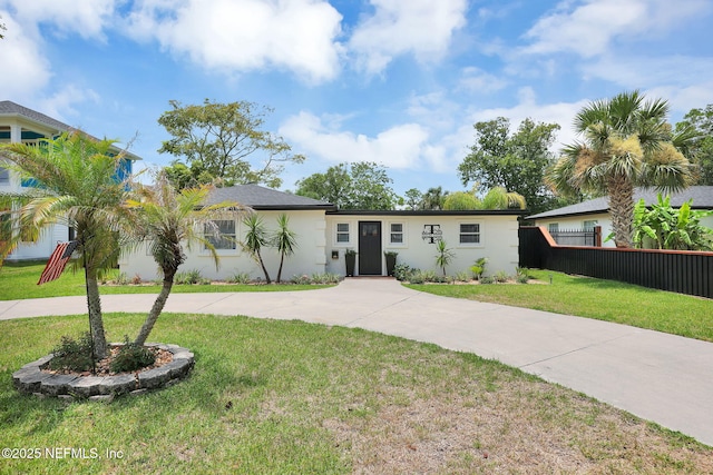 ranch-style home with stucco siding, driveway, a front yard, and fence