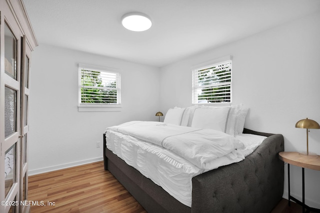 bedroom with baseboards and wood finished floors