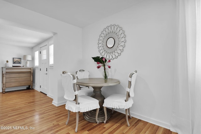 dining space featuring baseboards and light wood-style flooring