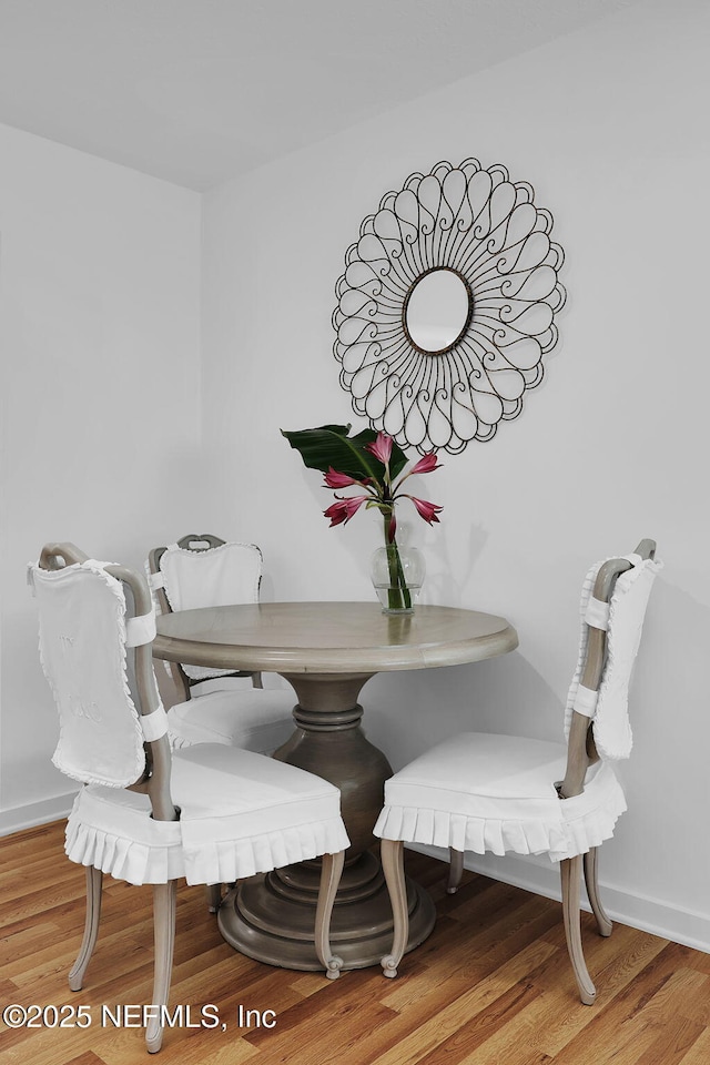 dining space with wood finished floors and baseboards