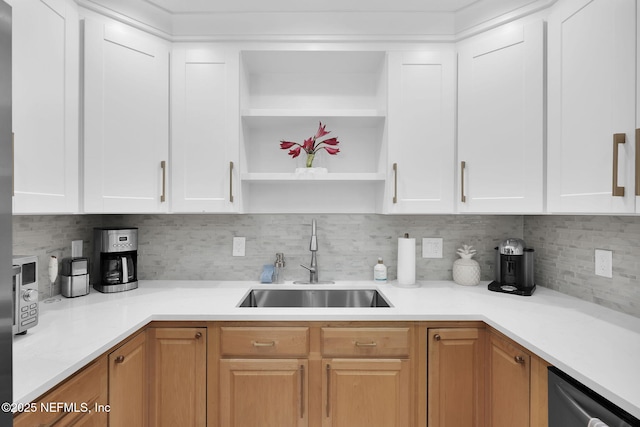 kitchen with decorative backsplash, open shelves, light countertops, and a sink