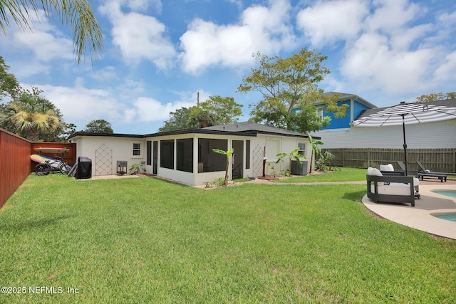 back of house with a fenced in pool, a lawn, a fenced backyard, a sunroom, and a patio area