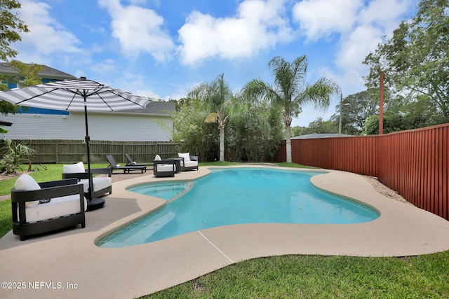 view of pool featuring a pool with connected hot tub, a fenced backyard, and a patio area