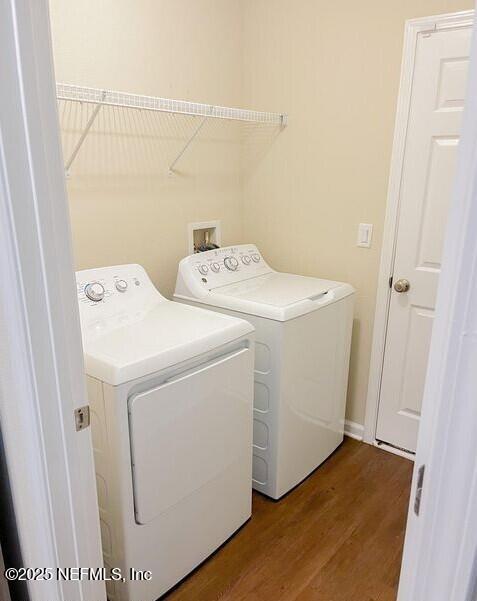 washroom with washing machine and dryer, laundry area, and wood finished floors