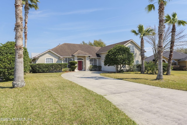 view of front of home with driveway, stucco siding, and a front yard