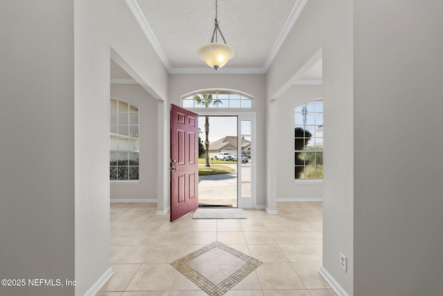 entryway featuring crown molding, a textured ceiling, baseboards, and light tile patterned floors