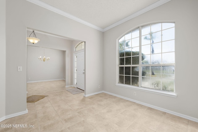 empty room featuring a textured ceiling, ornamental molding, baseboards, and an inviting chandelier