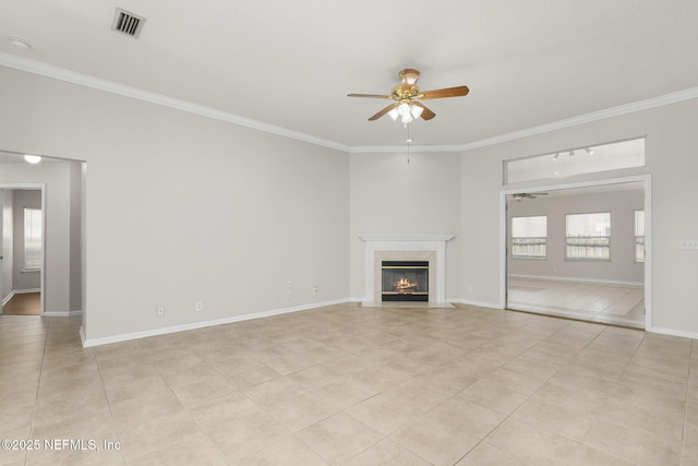 unfurnished living room featuring baseboards, visible vents, a ceiling fan, crown molding, and a fireplace