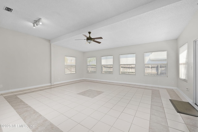 unfurnished room with visible vents, a textured ceiling, baseboards, and light tile patterned floors