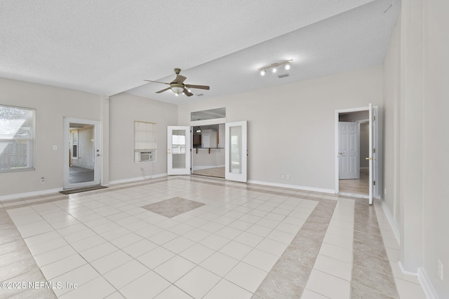 unfurnished living room with ceiling fan, baseboards, a textured ceiling, and light tile patterned flooring