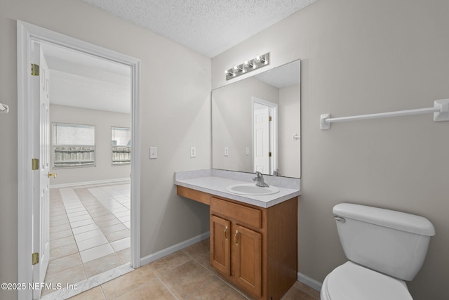 bathroom with baseboards, toilet, tile patterned flooring, a textured ceiling, and vanity