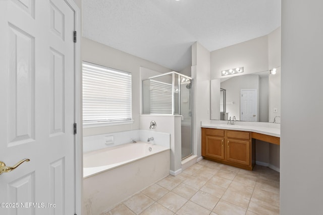 bathroom with a textured ceiling, a garden tub, vanity, tile patterned floors, and a stall shower