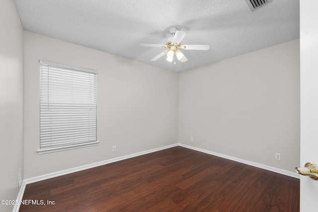 spare room featuring ceiling fan, a textured ceiling, visible vents, and wood finished floors