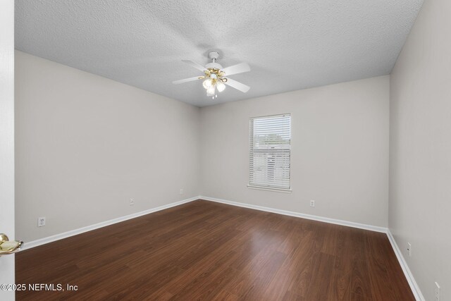 unfurnished room with ceiling fan, a textured ceiling, baseboards, and dark wood-style flooring