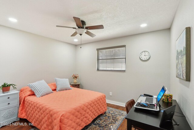 bedroom featuring a textured ceiling, baseboards, wood finished floors, and recessed lighting