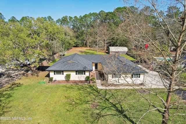 view of front of home featuring a front lawn and roof with shingles