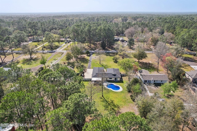 bird's eye view with a wooded view