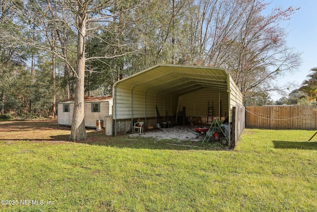 view of outdoor structure with fence and a detached carport