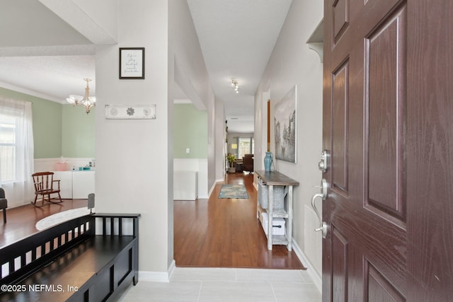 foyer entrance featuring light tile patterned floors, a chandelier, and a wealth of natural light