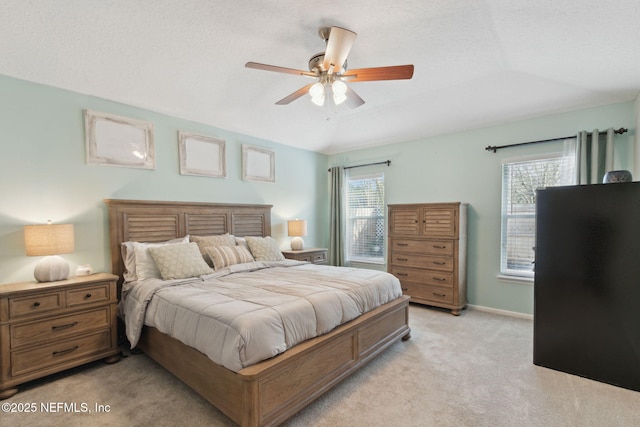 bedroom with light carpet, ceiling fan, baseboards, and vaulted ceiling