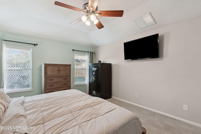 carpeted bedroom with ceiling fan, baseboards, vaulted ceiling, and a textured ceiling