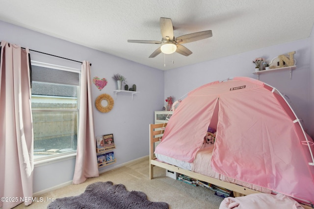 bedroom featuring carpet, baseboards, ceiling fan, and a textured ceiling