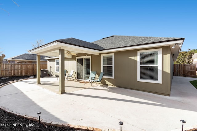 back of property featuring a ceiling fan, roof with shingles, fence, central air condition unit, and a patio area