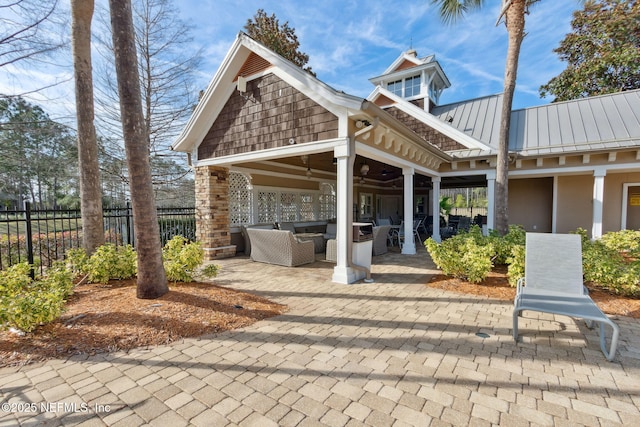 view of patio with a ceiling fan, fence, and an outdoor living space