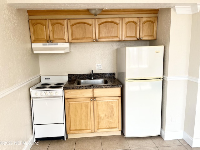 kitchen with light tile patterned flooring, under cabinet range hood, white appliances, a sink, and dark countertops