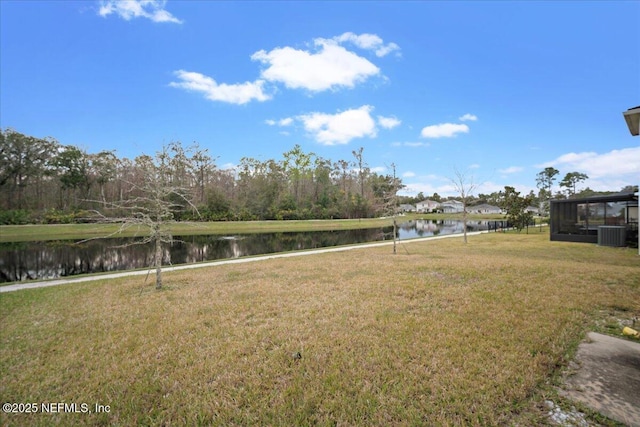 view of yard with central AC and a water view