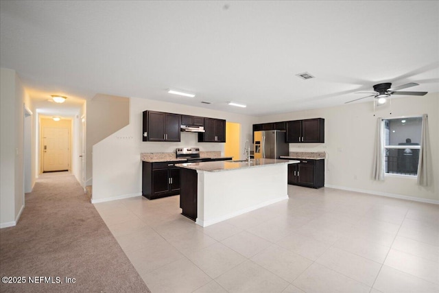 kitchen featuring visible vents, ceiling fan, appliances with stainless steel finishes, a kitchen island with sink, and under cabinet range hood