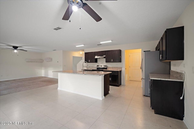 kitchen featuring under cabinet range hood, visible vents, open floor plan, appliances with stainless steel finishes, and a center island with sink