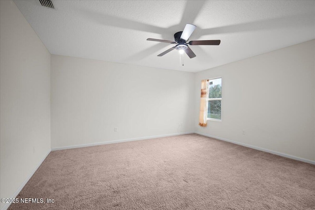 carpeted spare room with a ceiling fan, baseboards, visible vents, and a textured ceiling