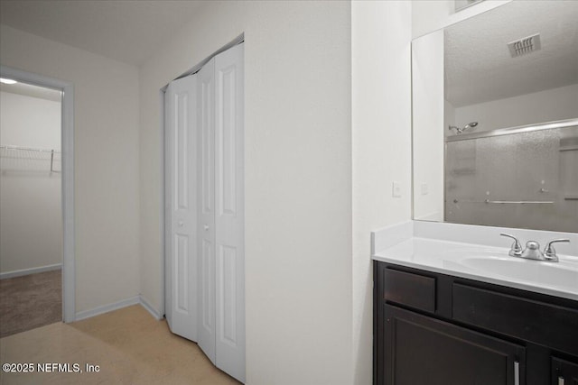 full bath featuring a closet, visible vents, vanity, and walk in shower