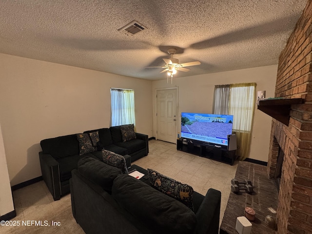 living area with ceiling fan, a textured ceiling, a fireplace, visible vents, and baseboards