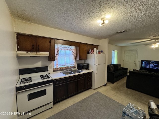 kitchen featuring white appliances, visible vents, light floors, under cabinet range hood, and a sink