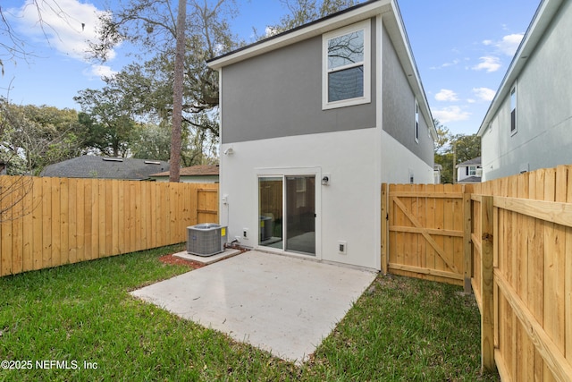 back of property with a fenced backyard, central air condition unit, a yard, a gate, and stucco siding