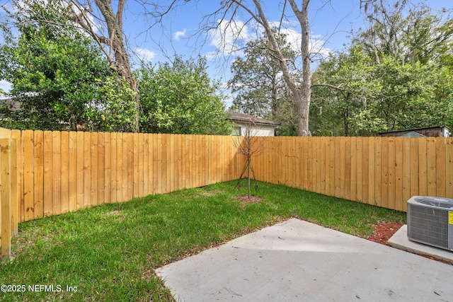 view of yard with central air condition unit, a fenced backyard, and a patio