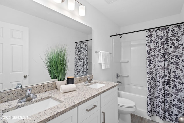 full bath with shower / tub combo with curtain, a sink, toilet, and double vanity