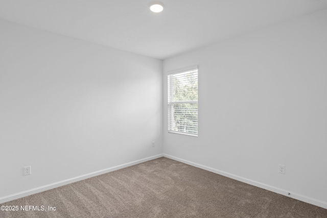 carpeted spare room with baseboards