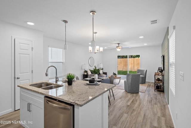 kitchen featuring visible vents, dishwasher, open floor plan, light wood-type flooring, and a sink