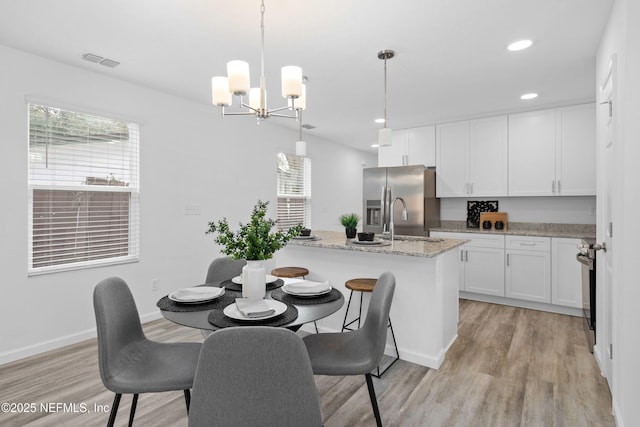 interior space with white cabinets, light stone counters, light wood-style floors, stainless steel refrigerator with ice dispenser, and recessed lighting