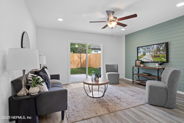 living area with baseboards, ceiling fan, wood finished floors, and recessed lighting