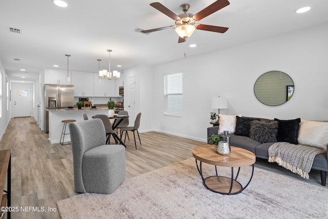 living room featuring light wood-type flooring, visible vents, and recessed lighting