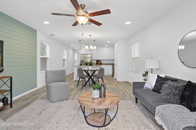 living area featuring wood walls, light wood-style flooring, and recessed lighting