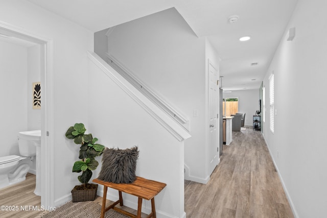 corridor featuring light wood-style flooring and baseboards