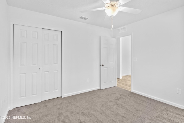 unfurnished bedroom featuring visible vents, baseboards, a closet, and carpet flooring